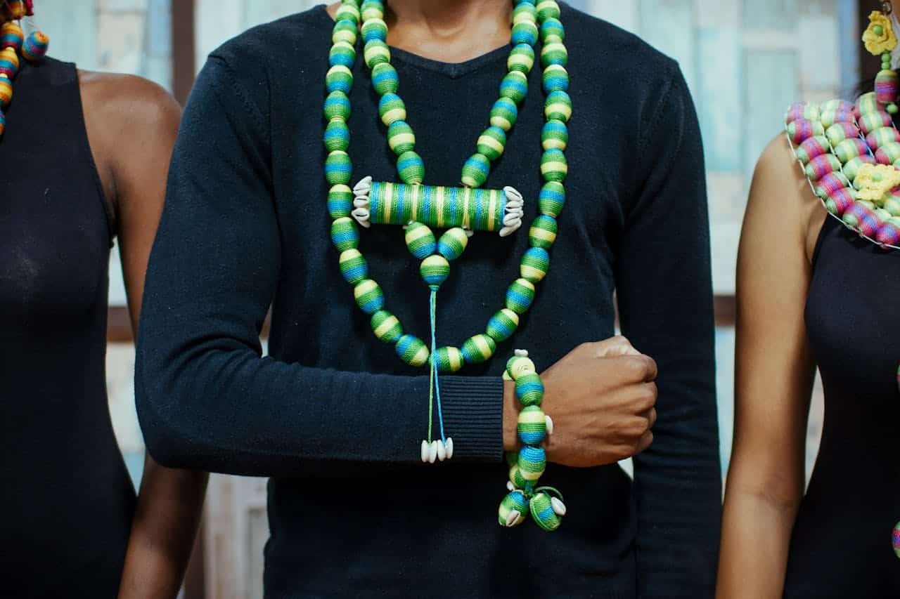 Colorful beaded necklaces and bracelets adorn diverse models during a fashion photoshoot.